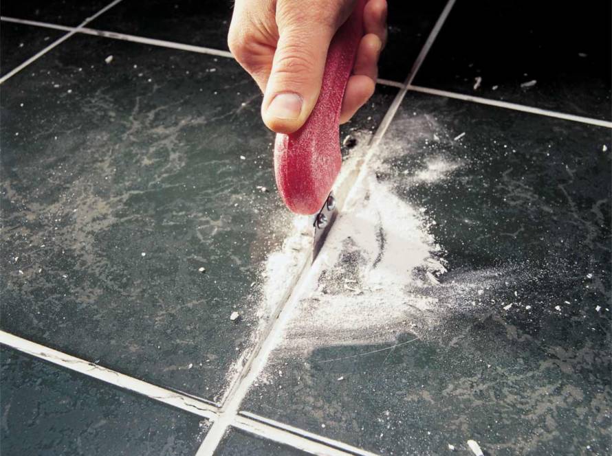 grout and calking technician preparing new regrout of floor tiles