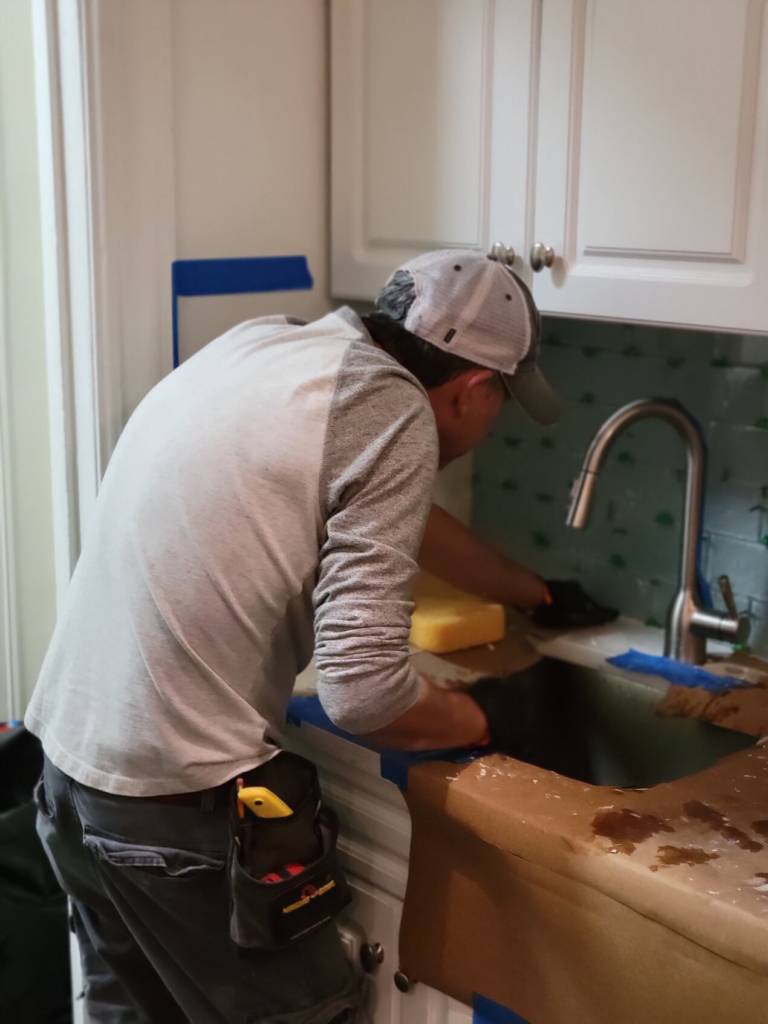 man preparing kitchen tile wall for repair and new tile installation